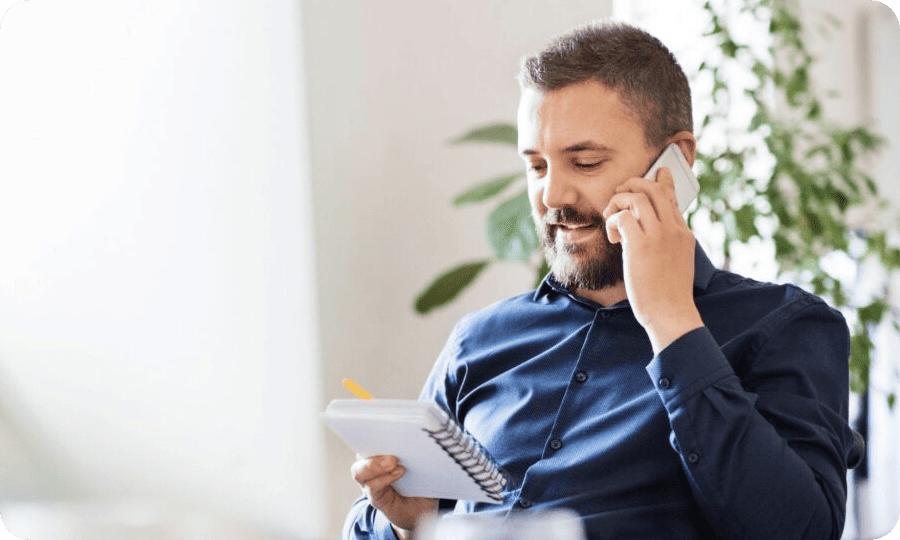 man on phone looking at notepad