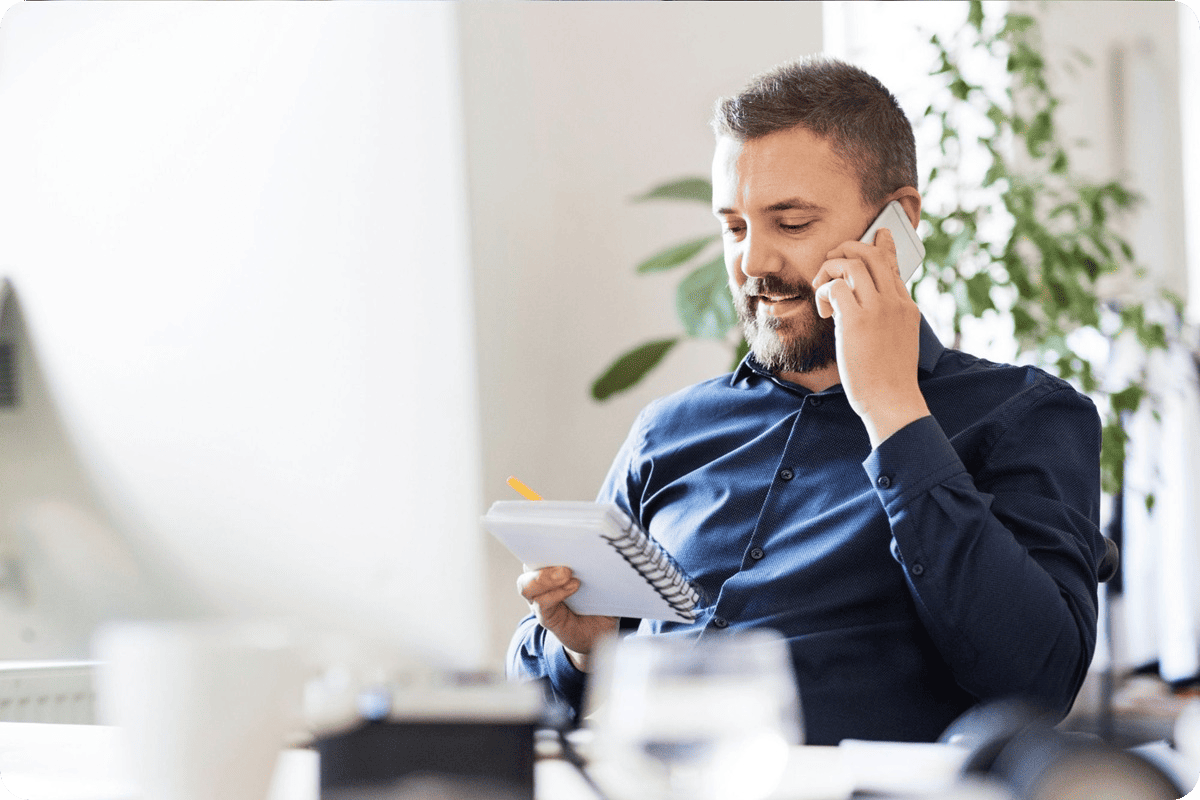 man on phone looking at notes