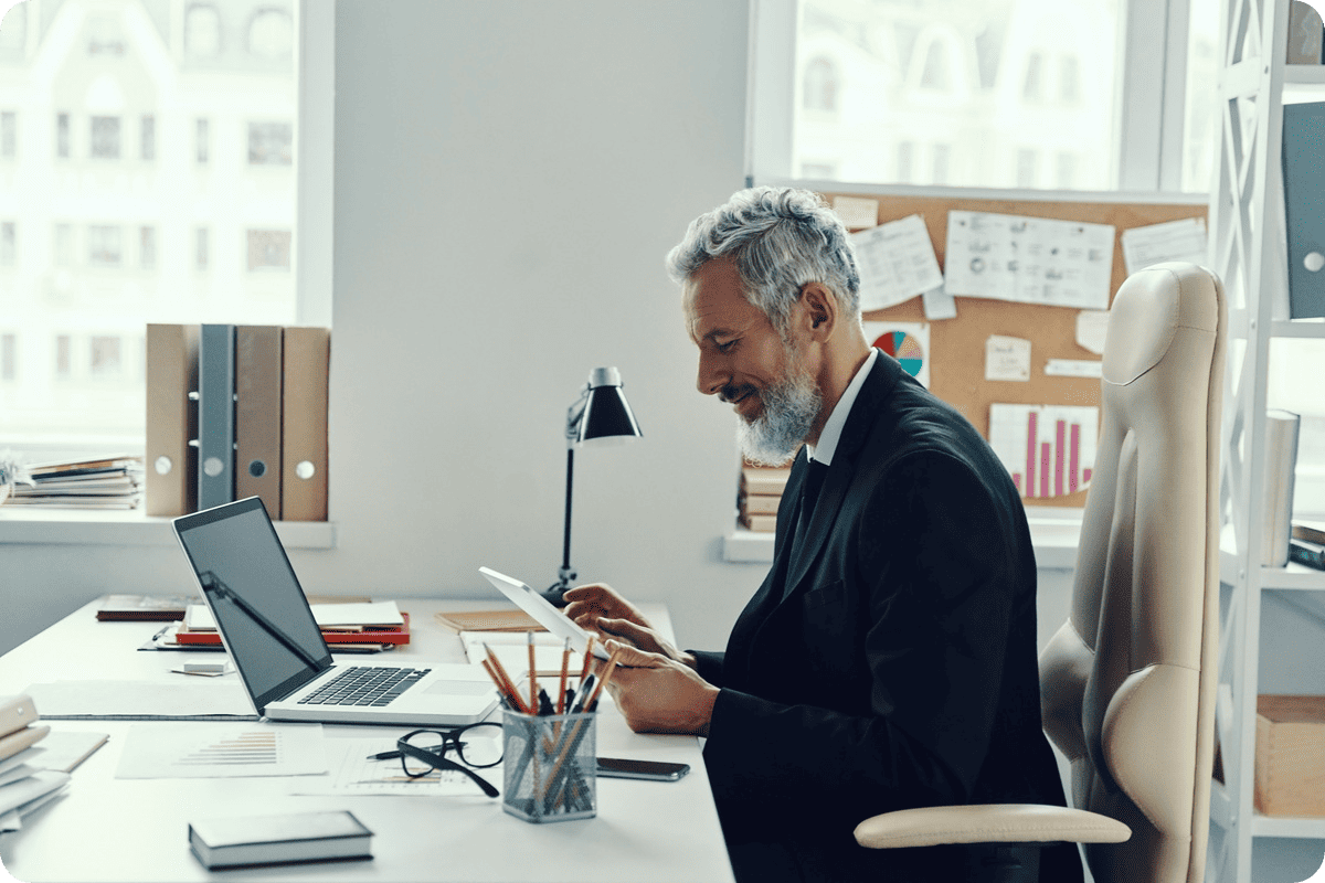 man at desk looking at ablet